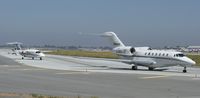 N948QS @ KSJC - NetJet's 2001 Cessna Citation X taxing out while a P180 taxis out behind it at San Jose International Airport, CA. - by Chris Leipelt