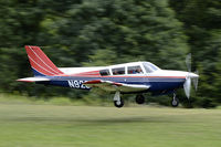 N9284P @ NY94 - Comanche 260B landing on grass - by Malcolm Dickinson