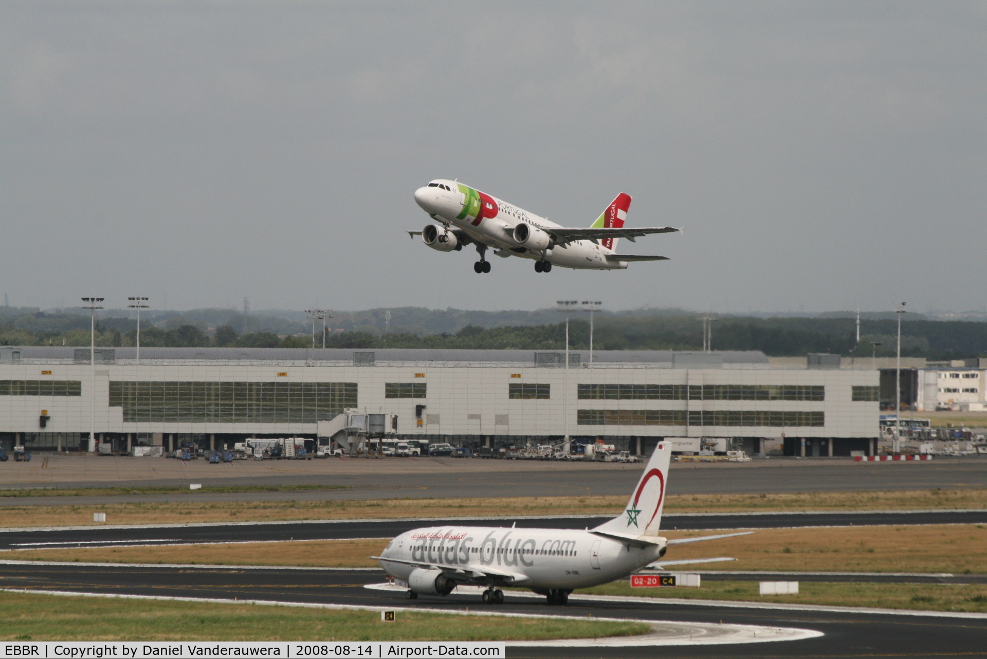 Brussels Airport, Brussels / Zaventem   Belgium (EBBR) - flight TP605 (A319-111 - CS-TTB) is taking off from rwy 20.  In background is Pier B - 