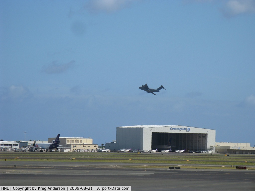 Honolulu International Airport (HNL) - A view of the cargo ramp and CO hangar, complete with a C-5 taking off beyond it.