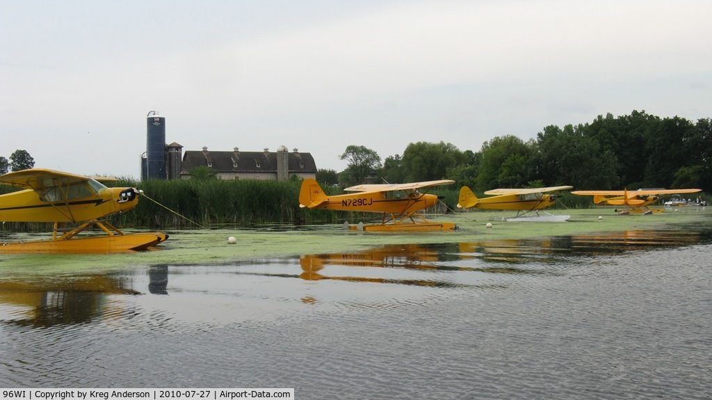 Vette/blust Seaplane Base (96WI) - An incredible sight, Piper Cubs lined up with an old farm in the background.