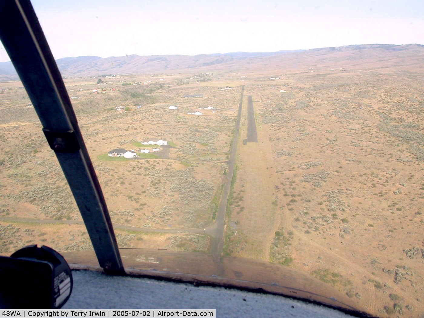 West Valley Airport (48WA) - On approach (with Tim Robel) from the east looking west. The airstrip rises to meet you at about a 2.4% rise or 100' rise in the 2,400' length. More hangar/homes have been built since this photo was taken.