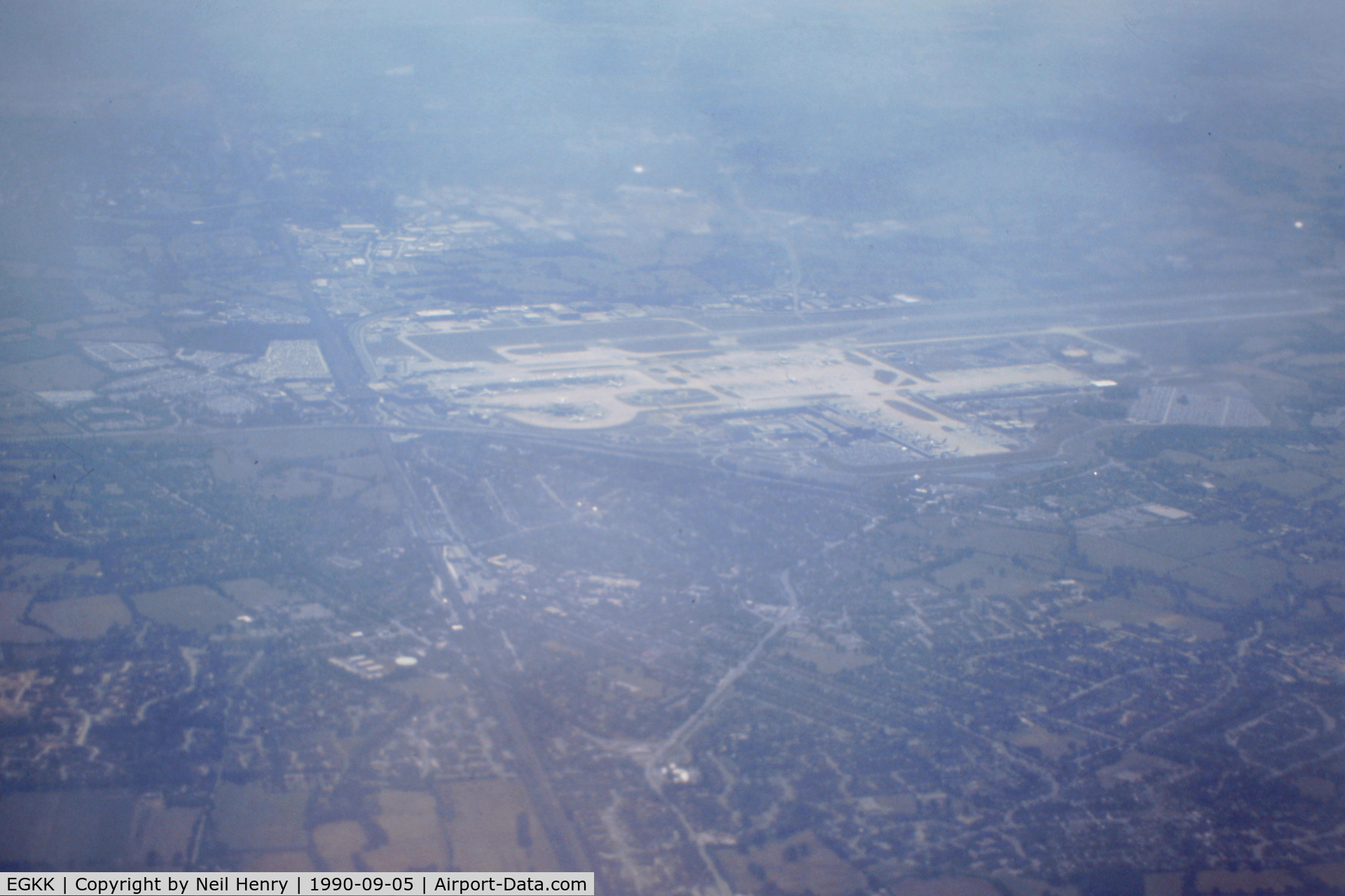 London Gatwick Airport, London, England United Kingdom (EGKK) - From scanned slide taken early September 1990 from departing NorthWest Airlines flight to MSP.  View shows airport from the north about 15k altitude and climbing.