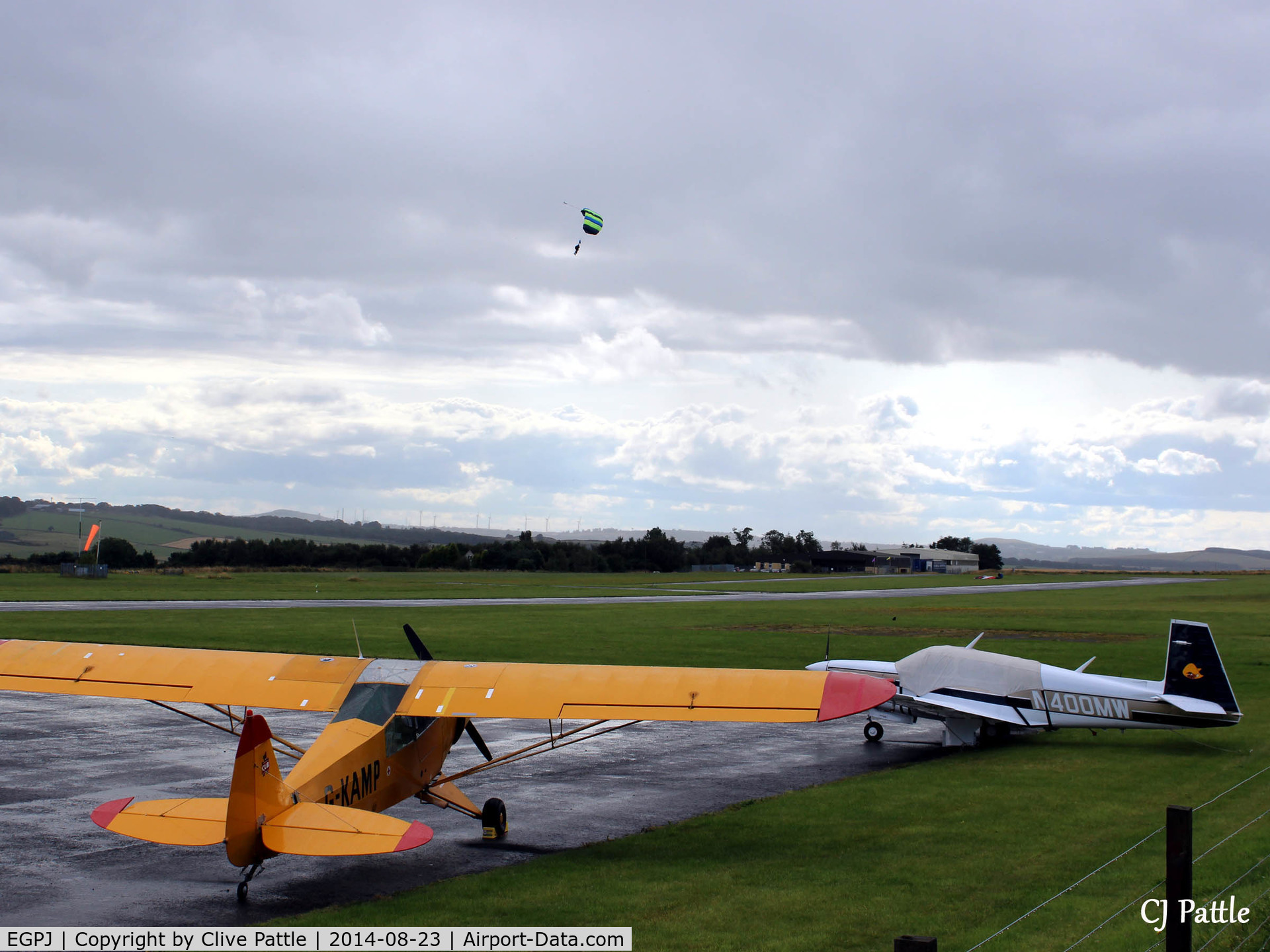 Fife Airport, Glenrothes, Scotland United Kingdom (EGPJ) - Airfield scene looking west, parked aircraft and skydiver landing in the background at Glenrothes EGPJ