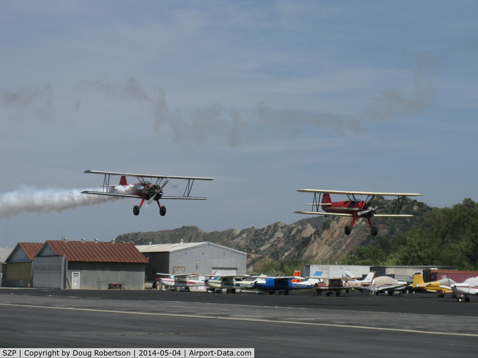 Santa Paula Airport (SZP) - Aviation Museum of Santa Paula 1st Sunday display day, N65124 with smoke and N66711 in echelon formation making fast low pass over Rwy 22, Bravo Zulu guys!