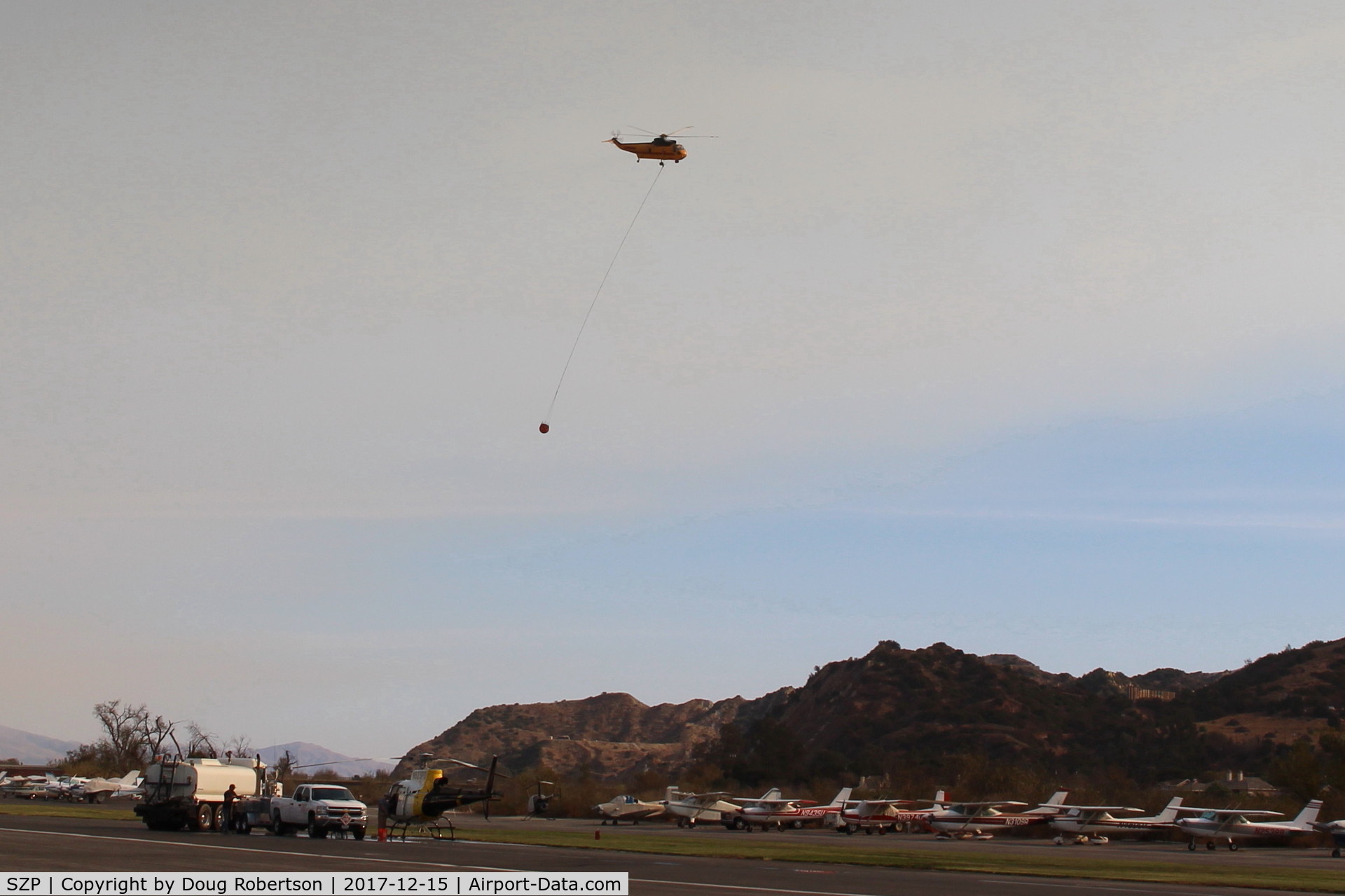Santa Paula Airport (SZP) - CROMAN helicopter with PHOS-CHEK sling load departing SZP FireBase, note smoky sky