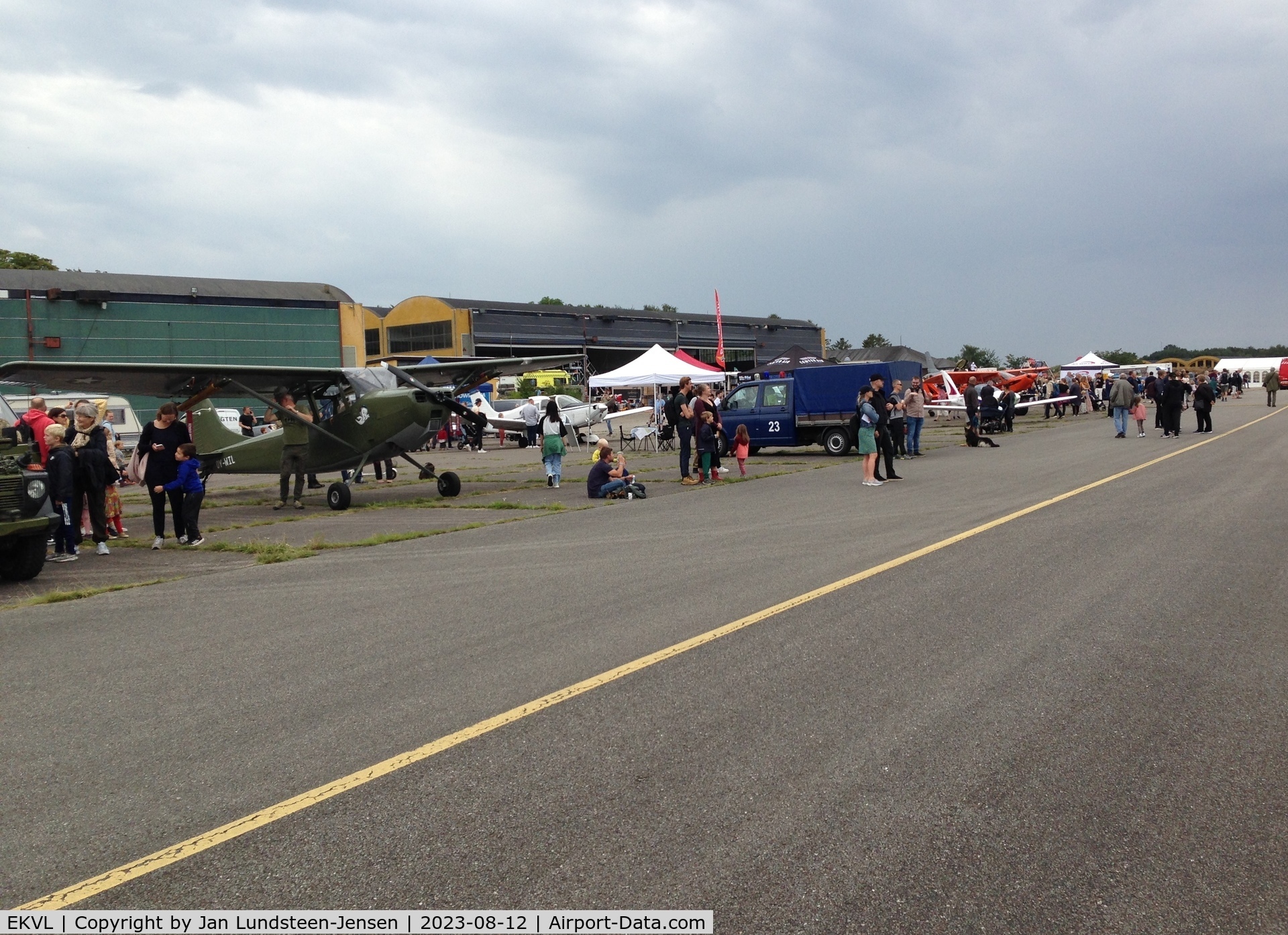 EKVL Airport - An airshow at the former Vaerloese Air Base in Denmark. To the left Cessna Bird Dog OY-WIL. Hangars 1 and 2 in the background.