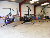 Wellesbourne Mountford Airfield - Robinson R22 and R44 helicopters in the Heli Air hangar at Wellesbourne Mountford - by Chris Hall