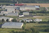 Wittman Regional Airport (OSH) - While departing Airventure on Runway 36 I was taking pictures of the Oshkosh truck inventory.  On a closer look of my photos I spotted Basler Turboprop Conversions facility. There's a B-25 in this photo too. - by Timothy Aanerud