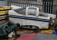 Fairoaks Airport - Unidentified PA-38 Tomahawk section in the compound at Fairoaks. The wings behind are from Cirrus SR22 G-TAAA which crashed at Denham. - by moxy