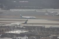 Charlotte/douglas International Airport (CLT) - Not top quality - it is cloudy and hazy, we are moving and the windows were scratched on my plane N744P (US A319 Piedmont colors).  ATI DC-8 lands on parallel runway, UPS 767 in foreground and large GA ramp in background - by Florida Metal
