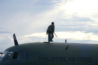 Lumbia Airport - 107 - Check out the Flight Engineer walking on the Roof of this Herc to check Fuel Level in the Wingtanks with a wooden stick he is carrying with him. - by The_Planespotter