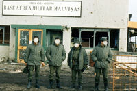 SFAL Airport - A Falklands War image from May 1982 with Argentinian Officers standing in front of the main airport terminal at Stanley SFAL. The building shows signs of damage, from RAF Black Buck Vulcan raids and Harrier GR.3 and Sea Harrier FRS.1 strafing attacks. - by Clive Pattle