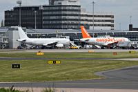 Manchester Airport, Manchester, England United Kingdom (EGCC) - on the left is LY-VEN A320 parked on its stand/gate and on the right is G-EZIL A319 EZY parked on its stand/gate - by andy-man-egcc