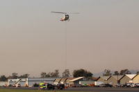 Santa Paula Airport (SZP) - Firebomber hovering over SZP FireBase with emptied sling load for replenishment. Fast turn-around time as Thomas fire here still burning (on shot date) just adjacent northern Santa Paula. Note smoky sky. - by Doug Robertson